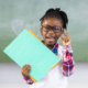 portrait-happy-schoolgirl-holding-file-classroom (1)