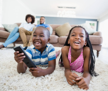 siblings-lying-rug-watching-television-living-room (1)